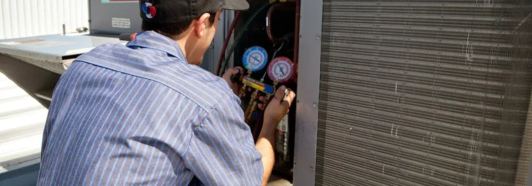 HVAC technician servicing a condenser unit in Tuckahoe