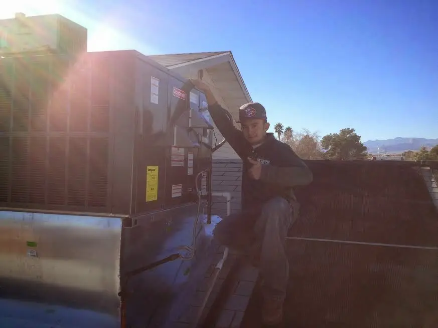 HVAC technician performing AC Tune-Up on a rooftop unit in Tuckahoe